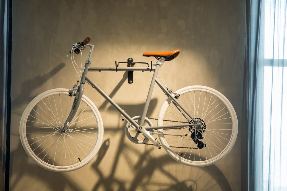 A white bike haniging on a wall hook