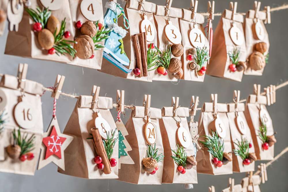 advent calendar made with decorated paper bags hanging from a rope