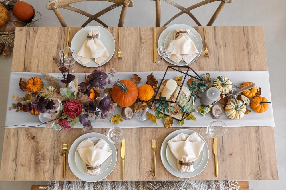 table setting with pumpkins and white plates