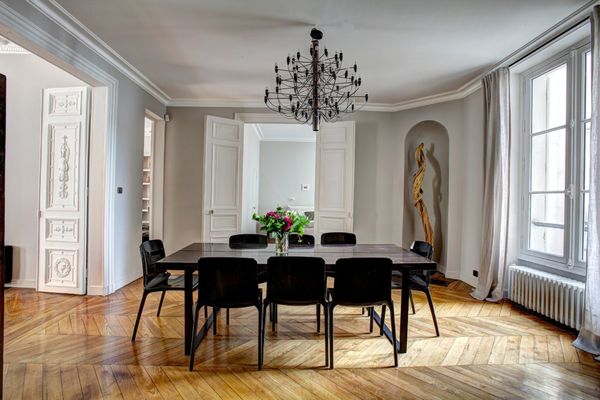 salle à manger élégante avec parquet et sculpture postmoderne