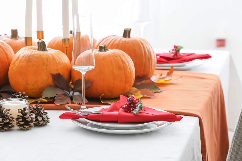 table set with pumpkins and orange table cloth