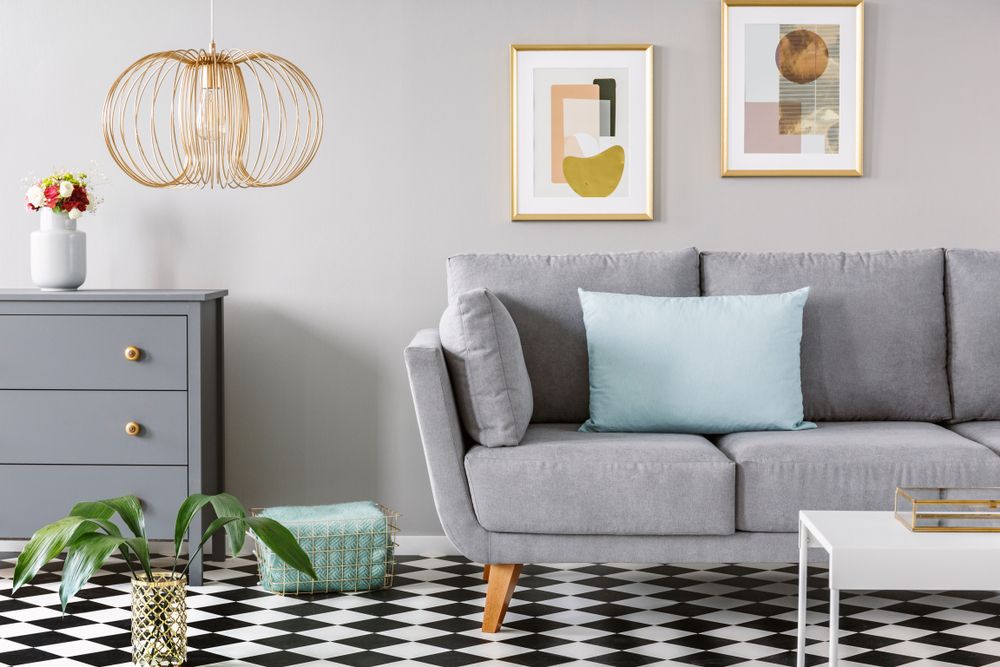 room with checkered linoleum flooring and grey sofa