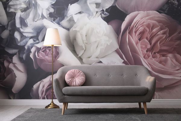 graues Sofa an einer Wand mit Blumentapeten, rosa Farben