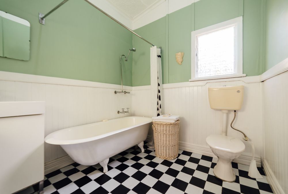 bathroom with black and white tiles and green walls