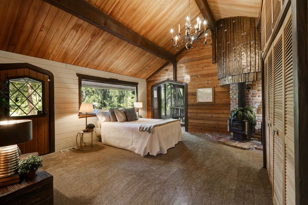 Wooden bedroom with high vaulted ceiling and fireplace