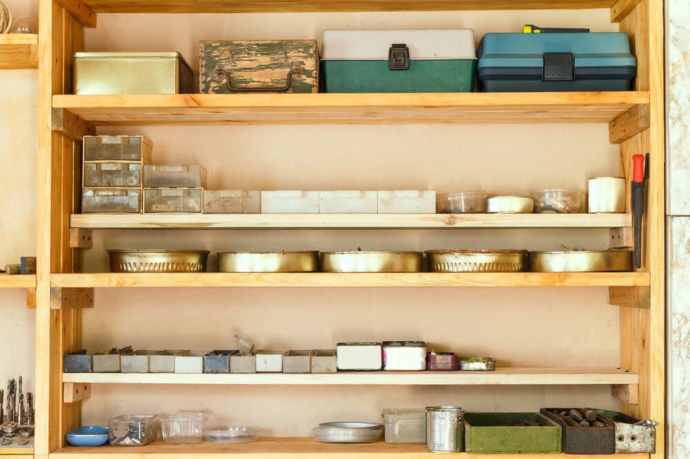 Wooden shelving units with different furniture in custom workroom.